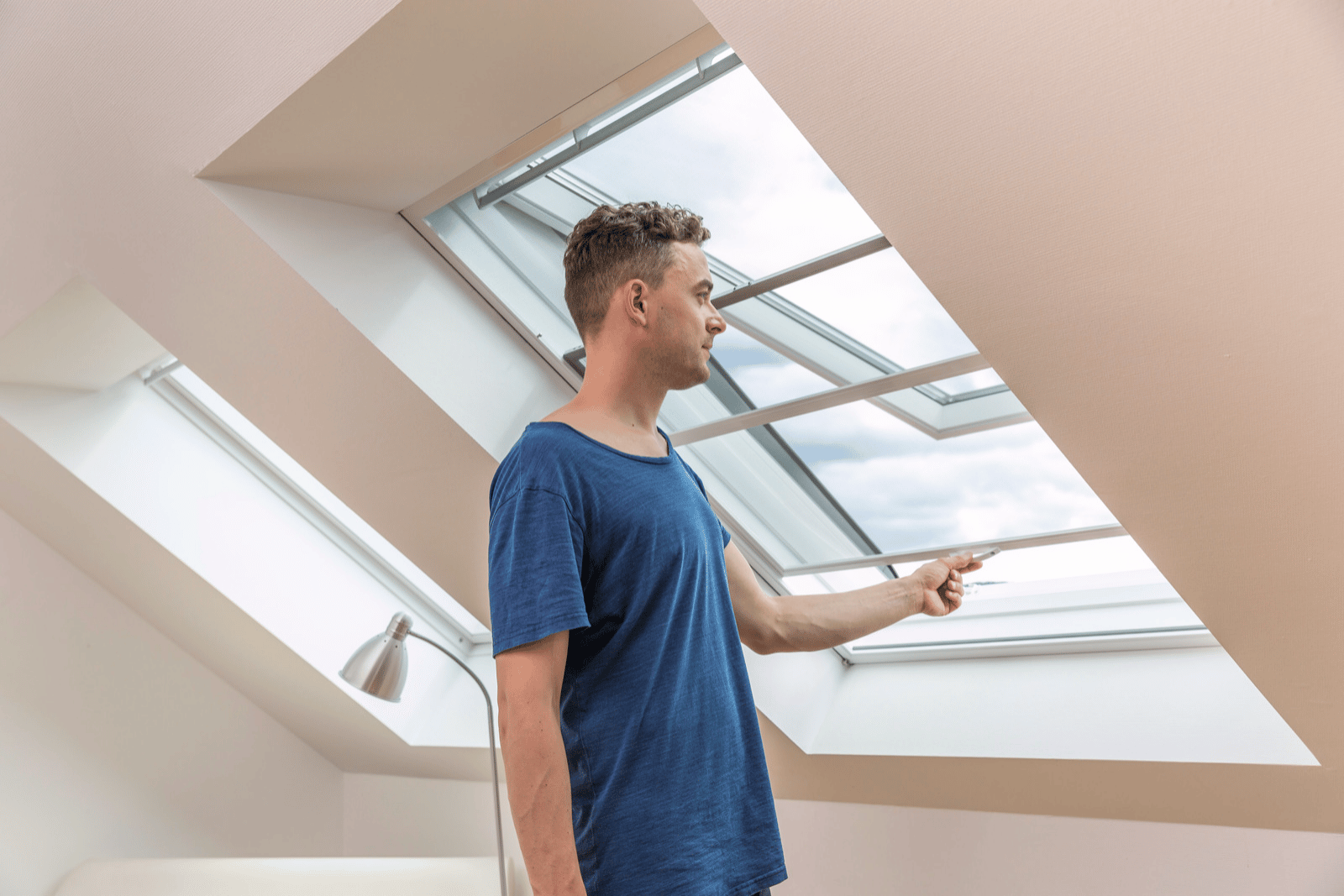 Mann öffnet Fliegengitter am Dachfenster
