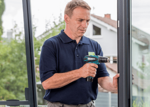 Koehler-Handwerker-bringt-Tuer-an-